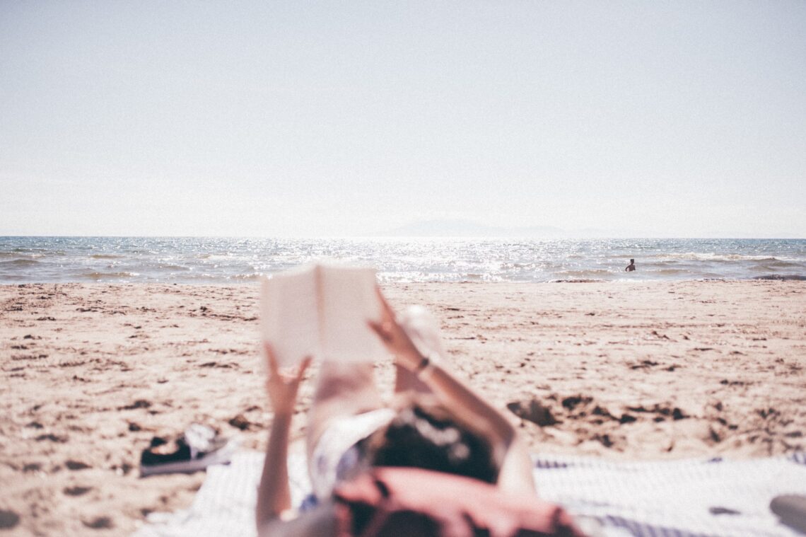 una ragazza che legge sulla spiaggia