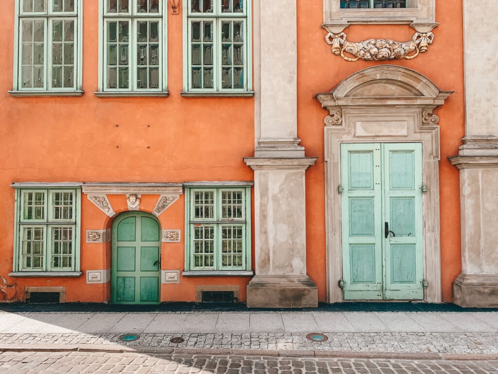 un palazzo con la facciata arancione e le finestre menta